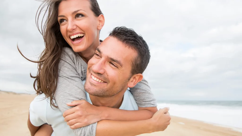 Intimkirurgi - et lykkelig par som holder rundt hverandrerundt sin mann og begge ler